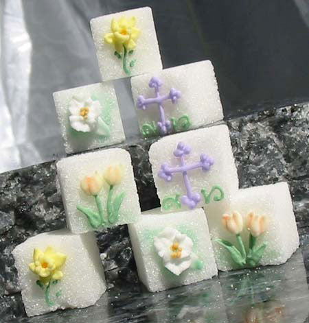 Decorated sugar cubes with spring flowers and a cross
